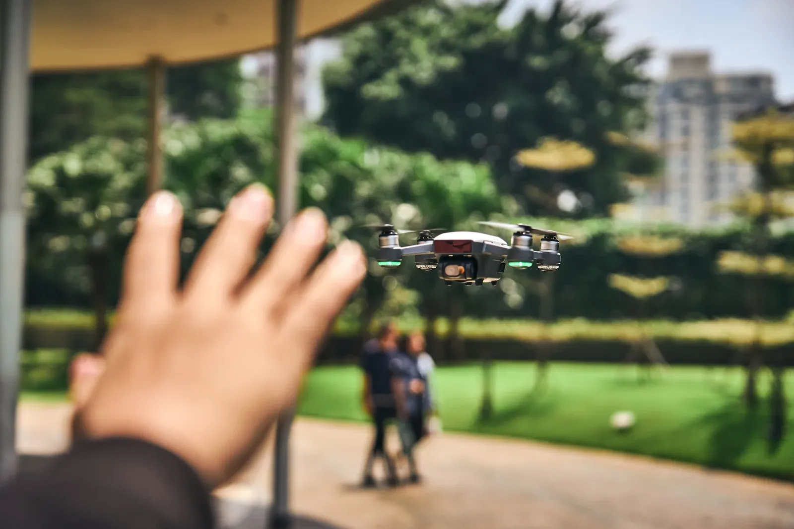 Operador civil pilotando um pequeno drone de consumo em área urbana