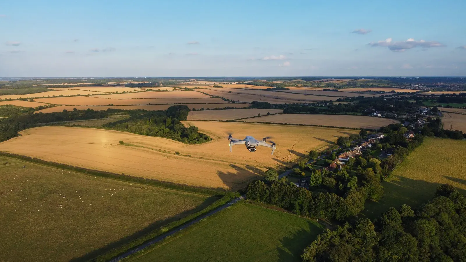 Drone comercial em voo de longo alcance sobre área rural, ilustrando operações BVLOS