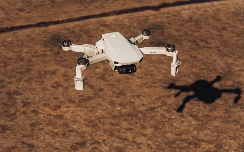 Drone quadricóptero sobrevoando terreno aberto ao entardecer