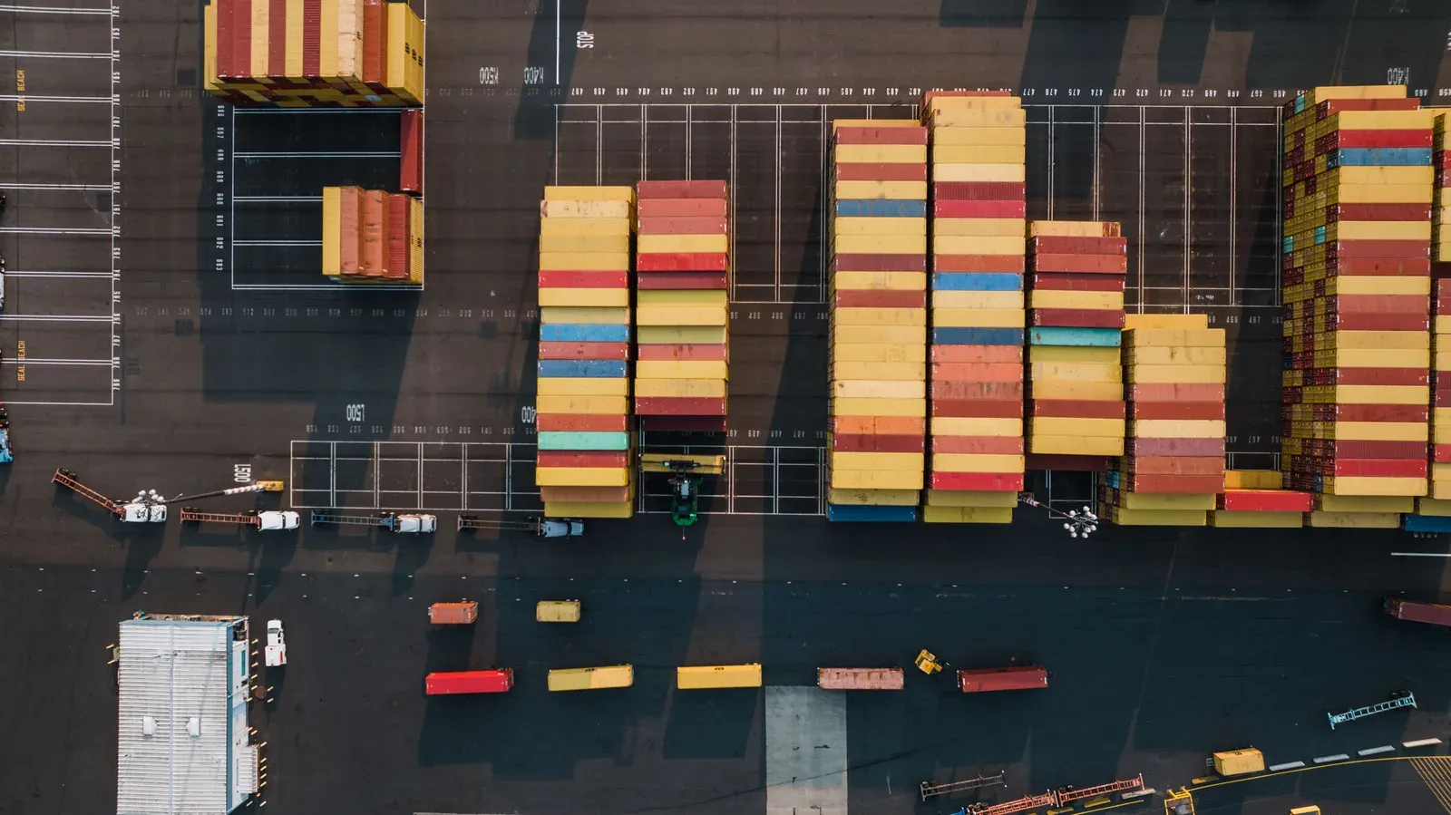 Aerial view of a shipping container port with stacked cargo