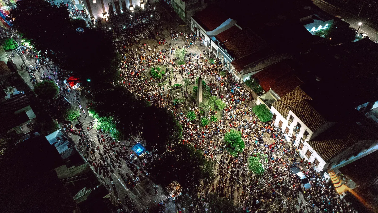 Vista aérea de grande evento ao ar livre com perímetro de segurança