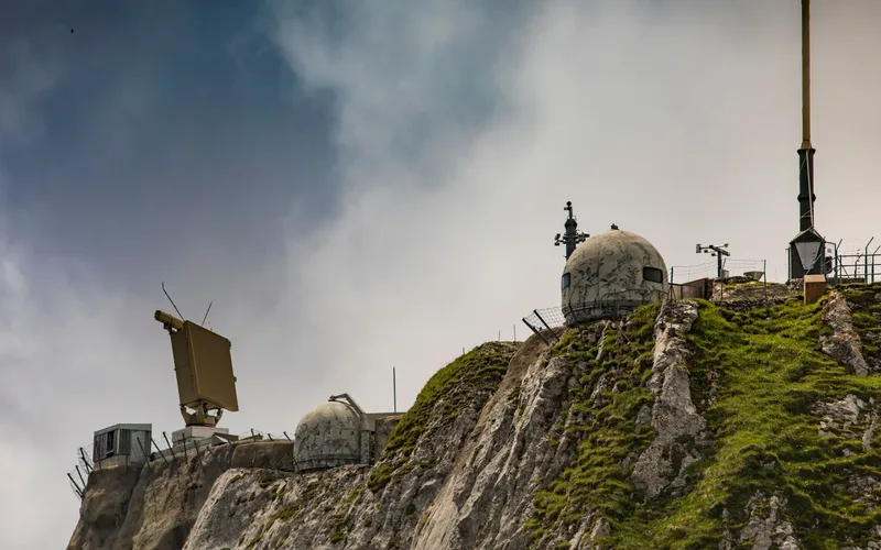 Sistema militar de defesa contra drones com antena de radar apontada para o céu