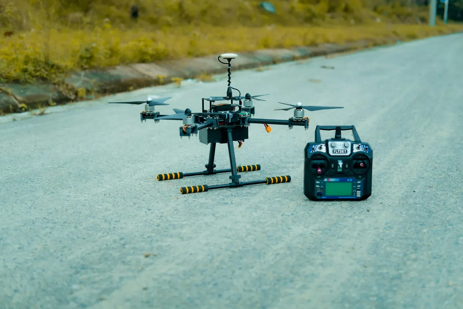 A large heavy-lift cargo drone hovering with an underslung payload on an airfield apron
