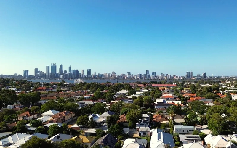Drone de entrega comercial sobrevoando área urbana ao entardecer