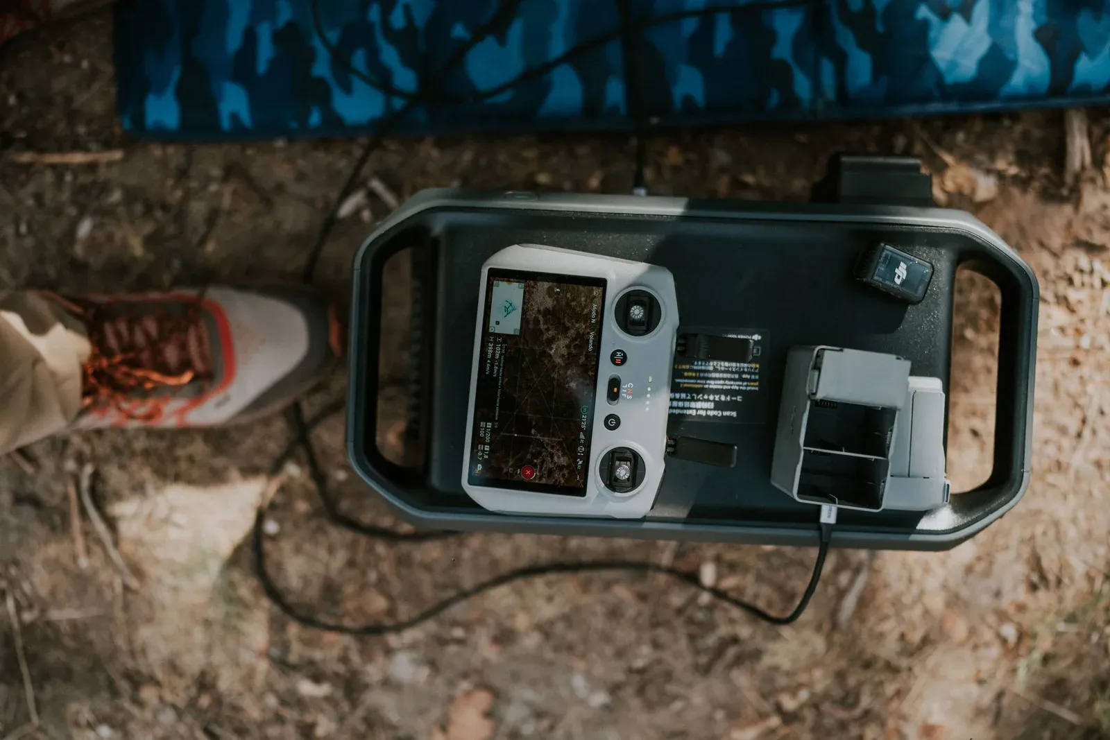 Drone operator monitoring a ground control station in the field