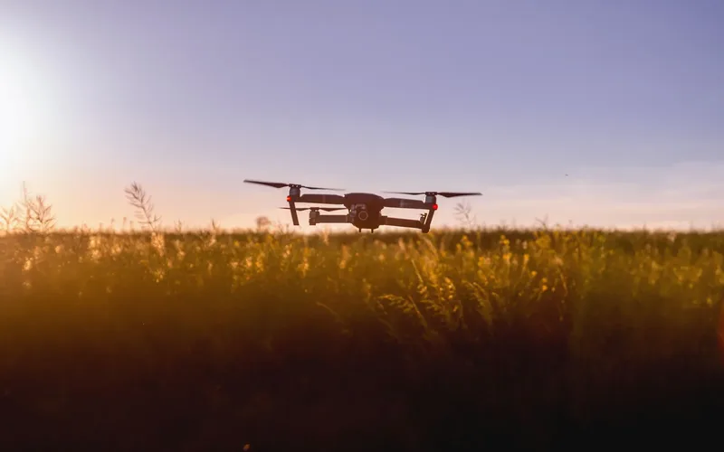 Enxame de pequenos drones militares voando em formação coordenada ao entardecer