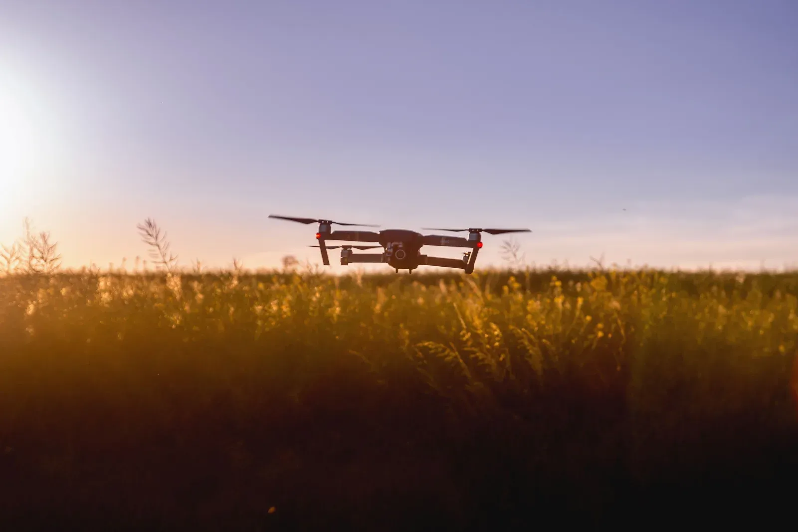 Enxame de pequenos drones militares voando em formação coordenada ao entardecer