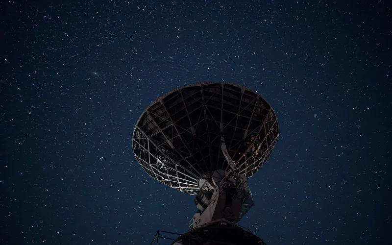 Sistema de radar de defesa aérea apontado para o céu noturno sobre uma cidade