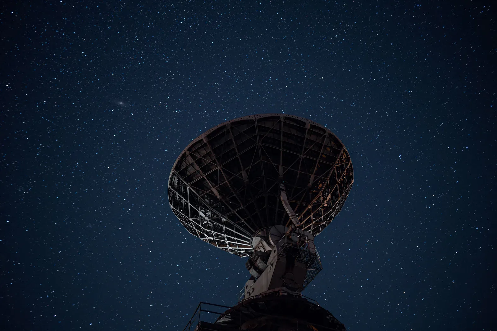 Sistema de radar de defesa aérea apontado para o céu noturno sobre uma cidade