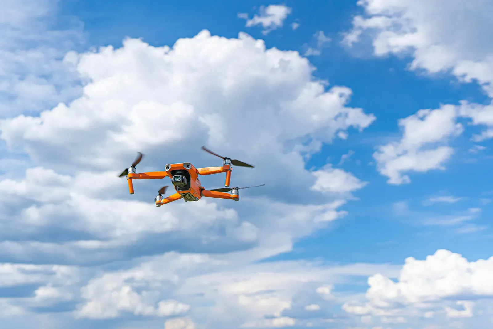 Delivery drone flying through windy conditions under a cloudy sky
