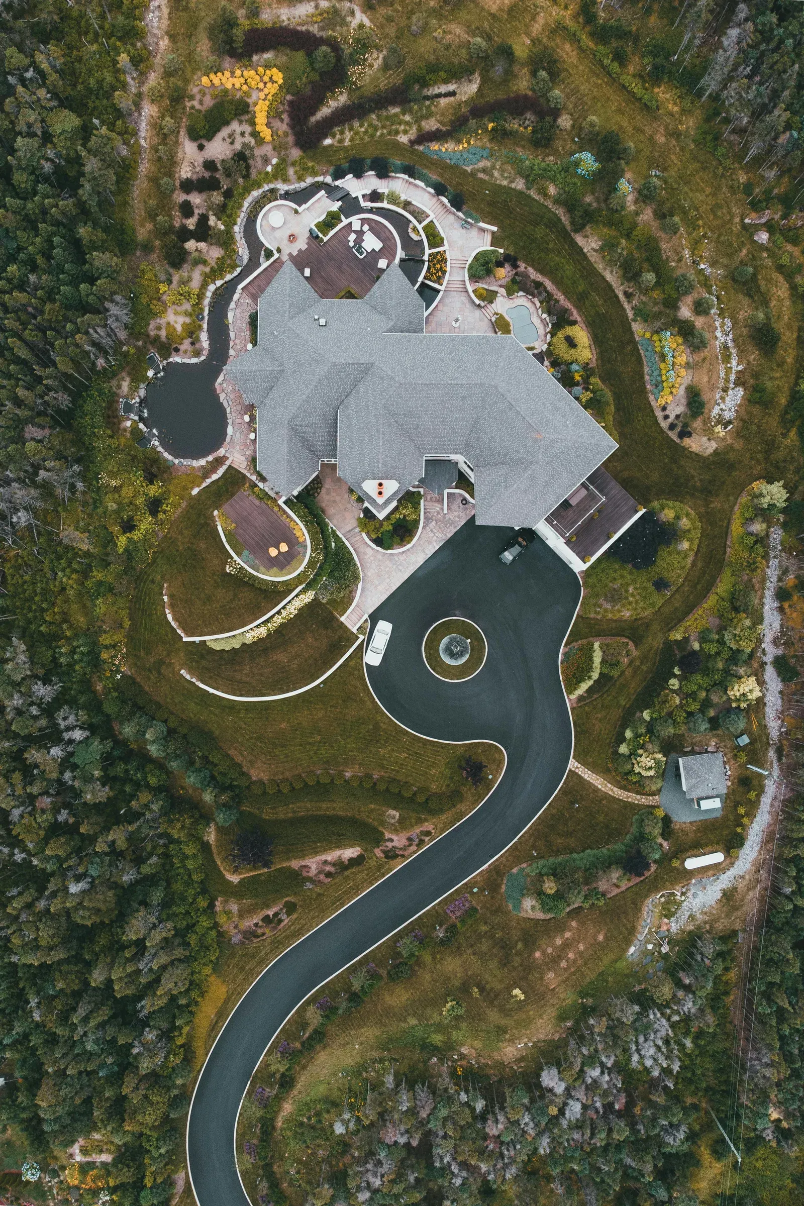 Package descending on a tether from a delivery drone to a residential driveway