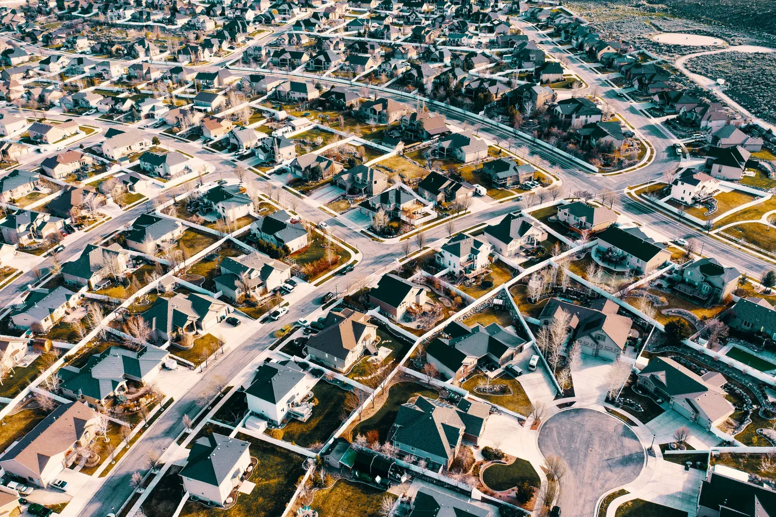 Fixed-wing delivery drone flying above a suburban neighborhood
