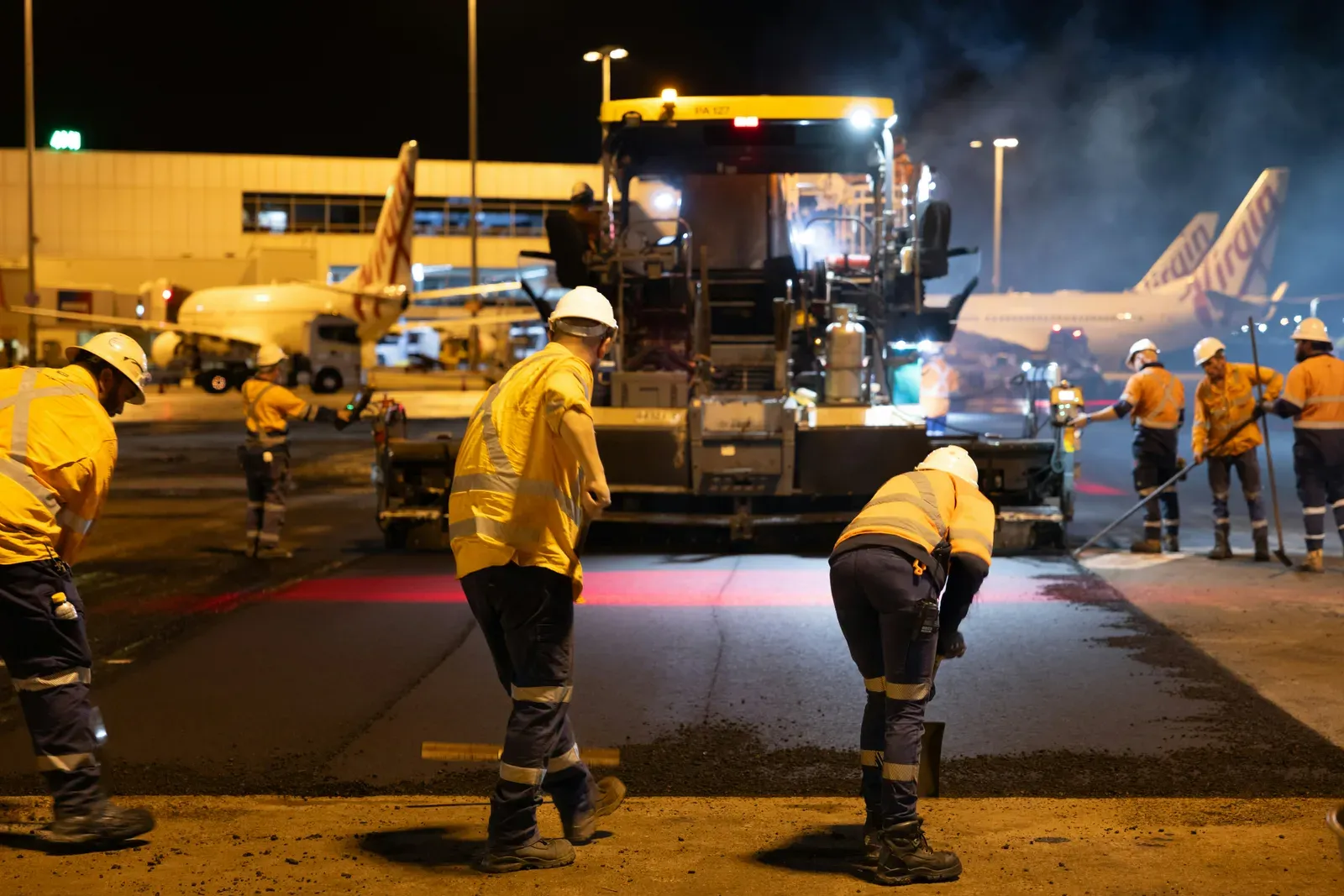 Security personnel on an airport tarmac at night