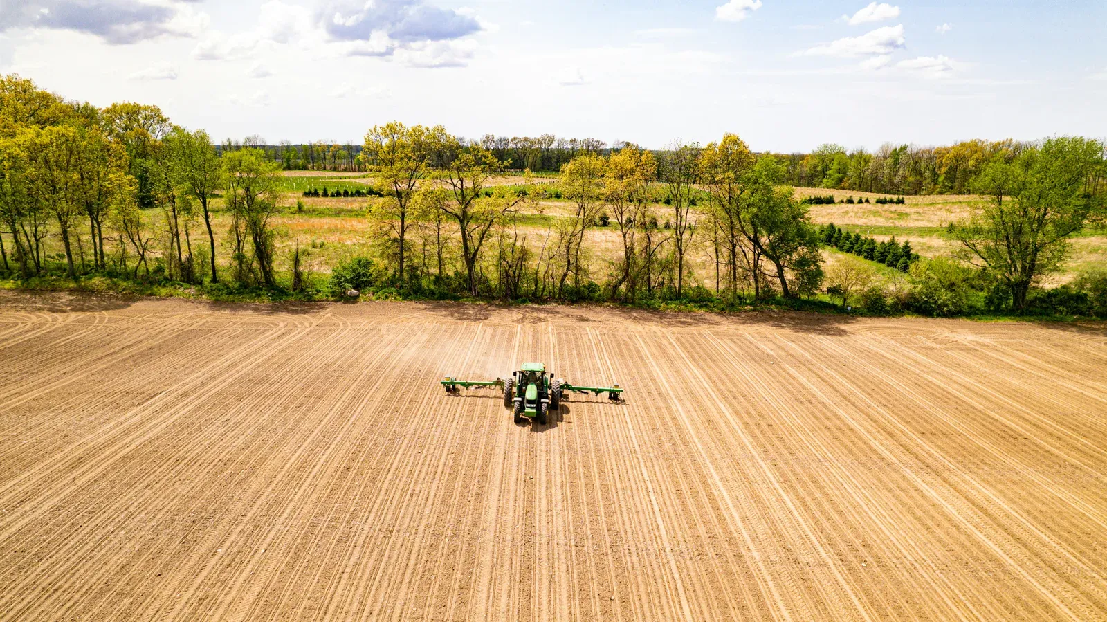 Heavy-lift agricultural drone spraying a large farmland plot