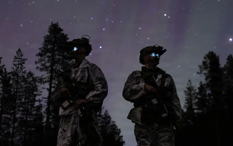 Small quadcopter drone flying against a dark night sky