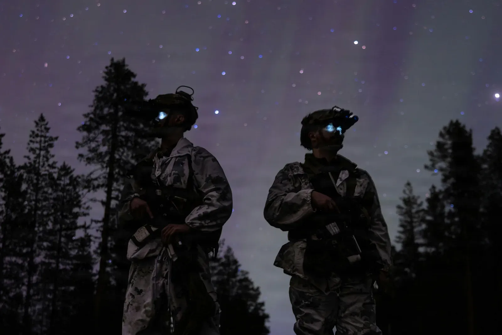 Small quadcopter drone flying against a dark night sky