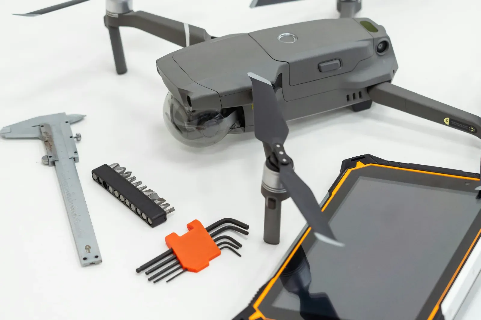 Drone spare parts and batteries laid out on a workshop bench