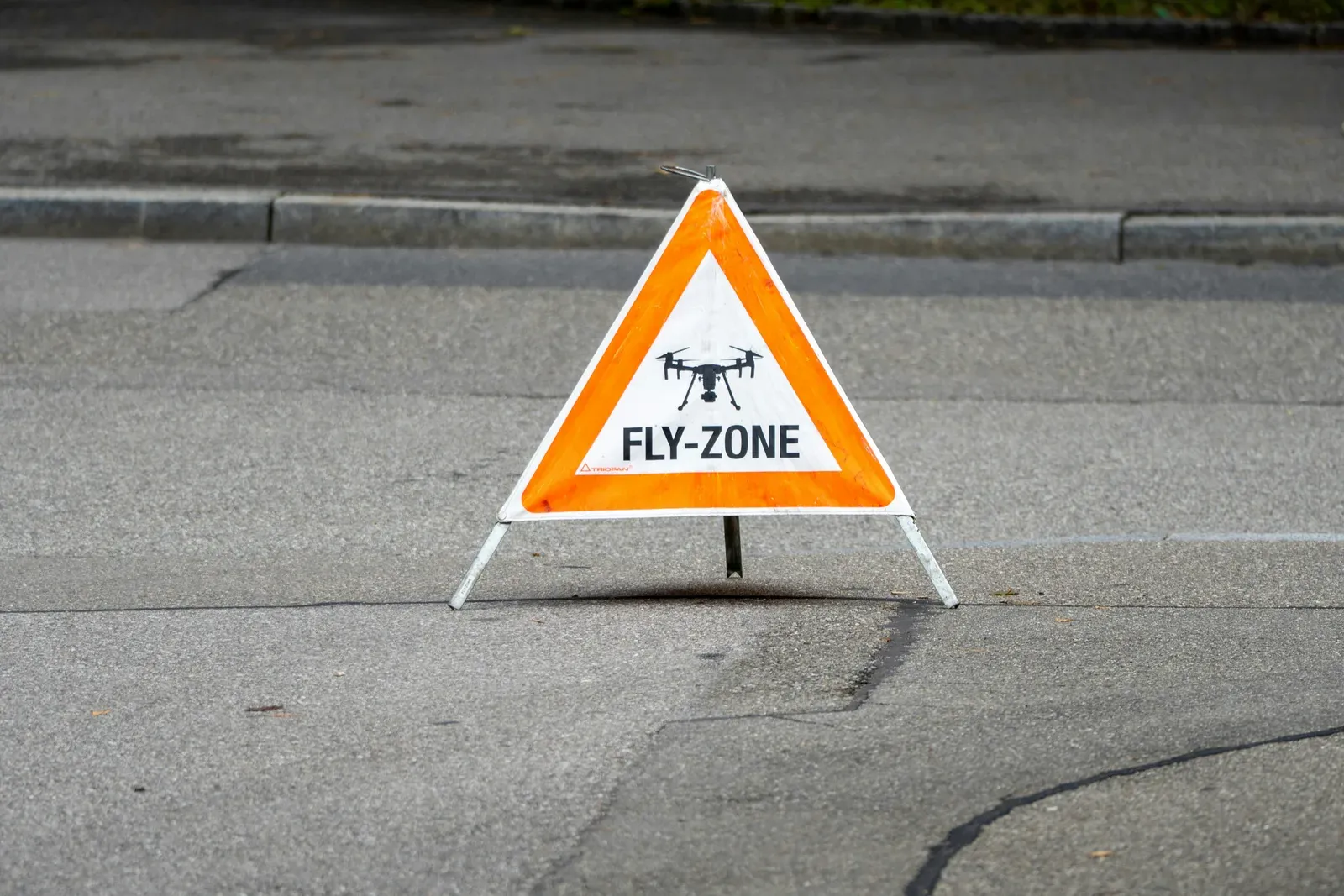 Small white quadcopter drone taking off during a field deployment