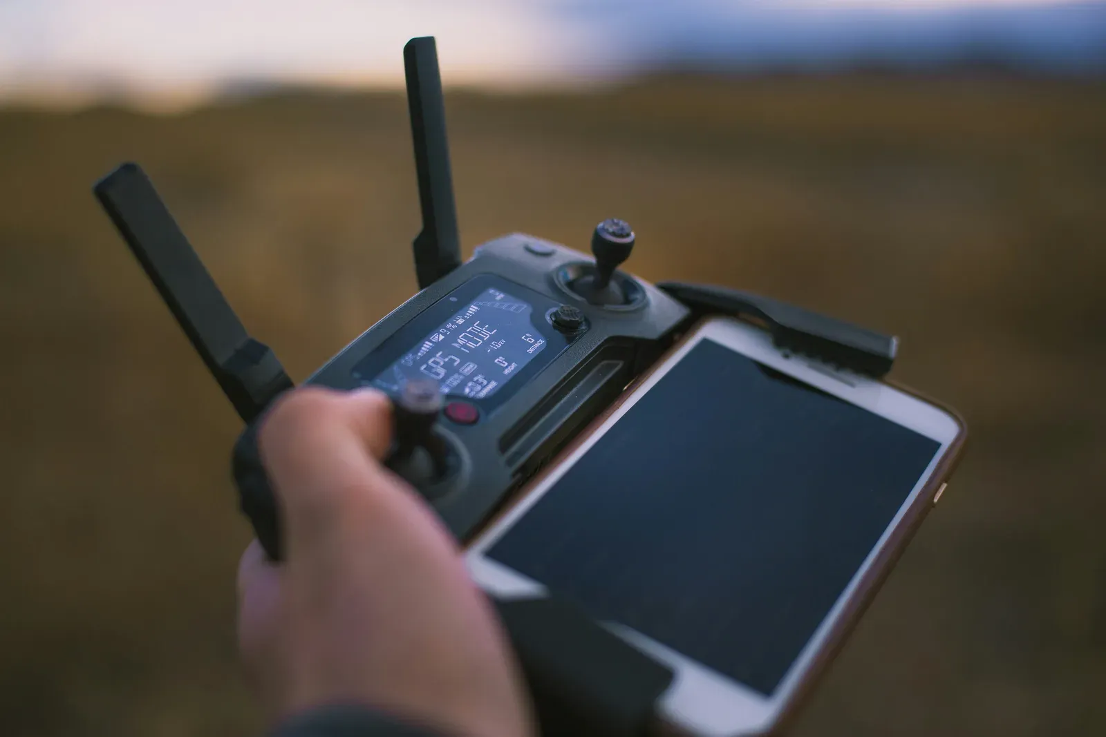 Operador segurando controle remoto de drone agrícola com base RTK ao fundo