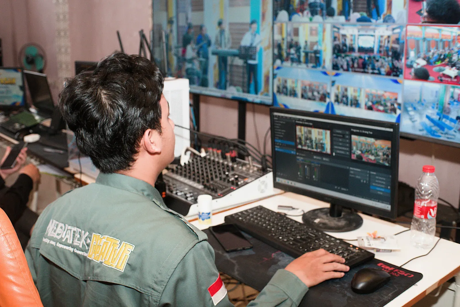 Operador monitora múltiplas telas em sala de controle e comando