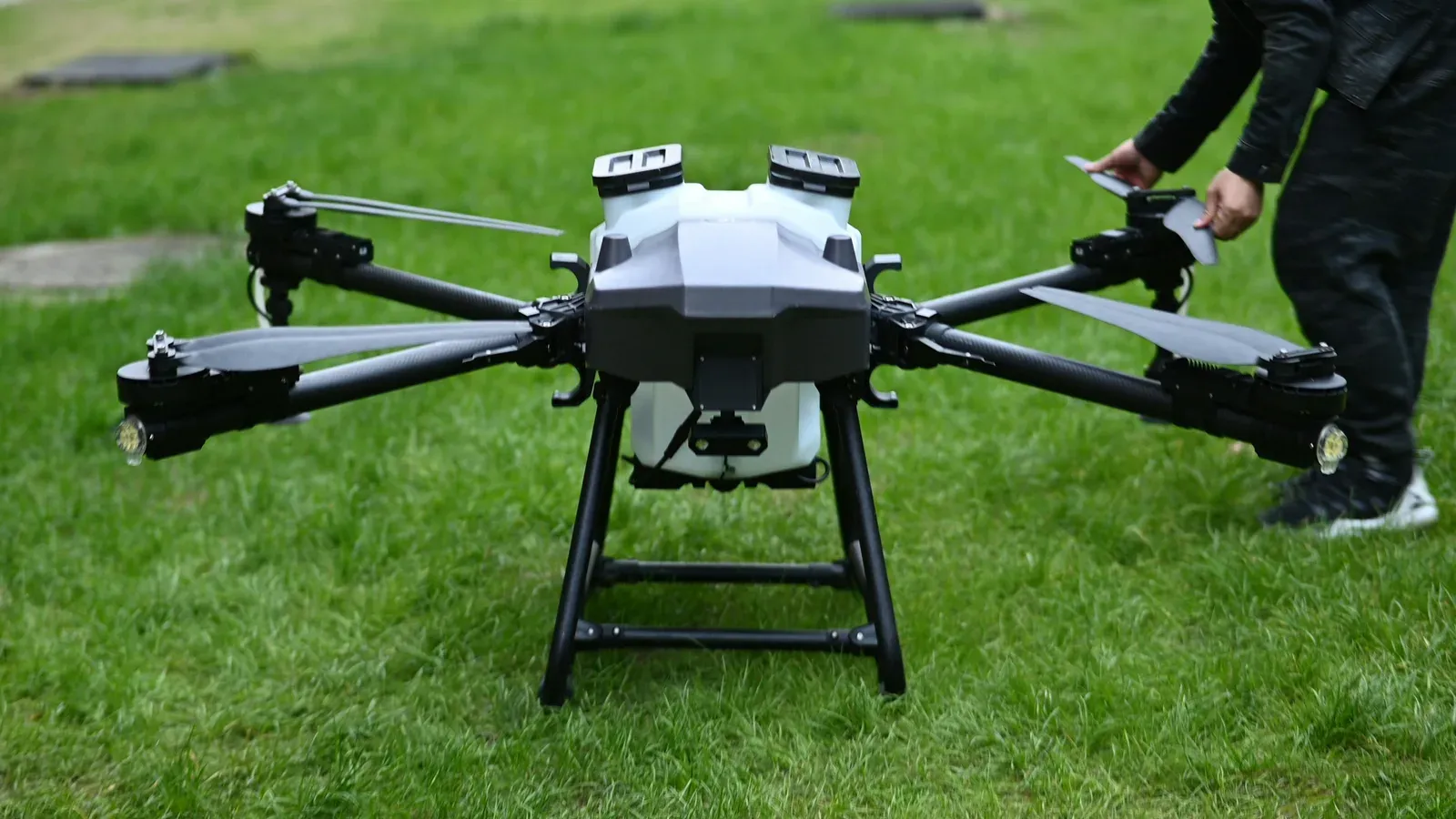 Técnico realizando manutenção em drone agrícola de grande porte